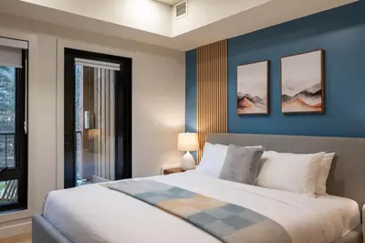 a bedroom with a large bed with blue walls at Brand New Canmore Studio - Cozy Mountain Getaway in Canmore
