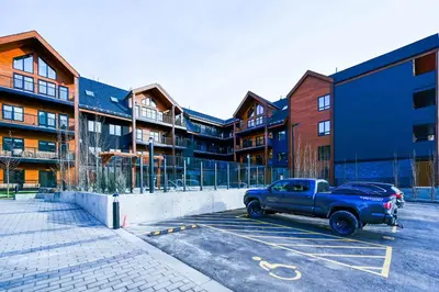a blue truck parked in a parking lot in front of a building at Brand New Canmore Studio - Cozy Mountain Getaway in Canmore