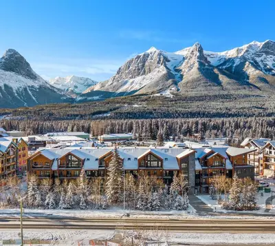 an aerial view of a resort with snow covered mountains at Brand New Canmore Studio - Cozy Mountain Getaway in Canmore