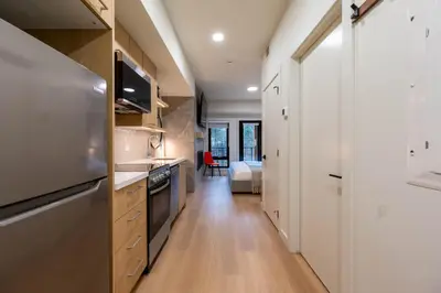 a kitchen with a refrigerator and a stove at Brand New Canmore Studio - Cozy Mountain Getaway in Canmore