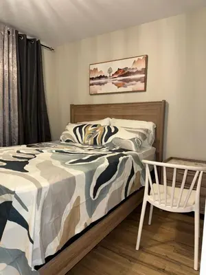 a bedroom with a bed and a chair at NorthEdge Suites in Edmonton