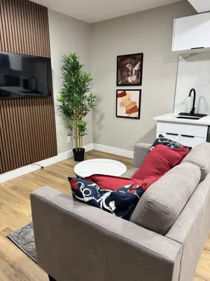 a living room with a gray couch with red pillows at NorthEdge Suites in Edmonton