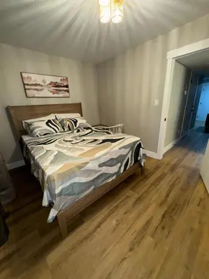a bedroom with a bed with a wooden floor at NorthEdge Suites in Edmonton
