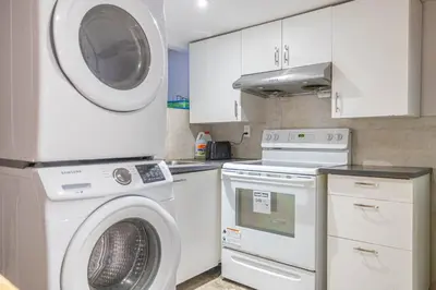 a kitchen with a washing machine and a washer at 2 BDRS at DT-Near 2 metros, Atwater Market, Concordia in Bélanger