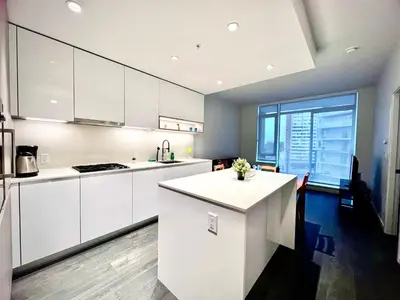 a kitchen with white cabinets and a large window at Warm and Cozy 1B1B near Richmond center in Richmond