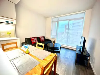 a living room with a table and a couch at Warm and Cozy 1B1B near Richmond center in Richmond