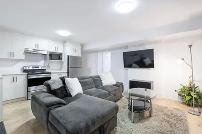 a living room with a couch and a table at Bright & Modern Surrey Basement Suite with Queen Beds & Parking in Surrey