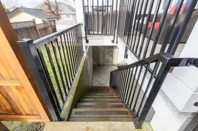 a stairway leading up to a house with a stair railing at Bright & Modern Surrey Basement Suite with Queen Beds & Parking in Surrey