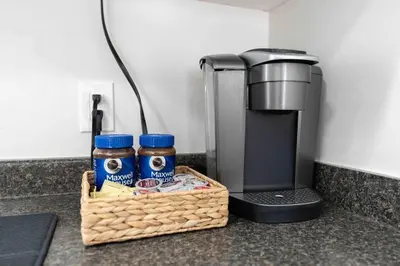 a basket of food and a coffee maker on a counter at Lovely Coach House in Langley with Queen Beds Pkg in Langley