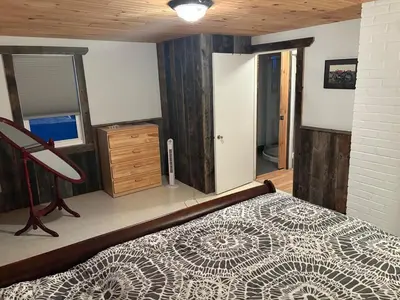a bedroom with a bed and a dresser and a mirror at maison de la Ferme in Bélanger