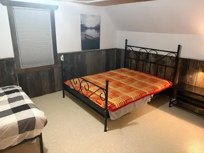 a bedroom with a bed and a window at maison de la Ferme in Bélanger