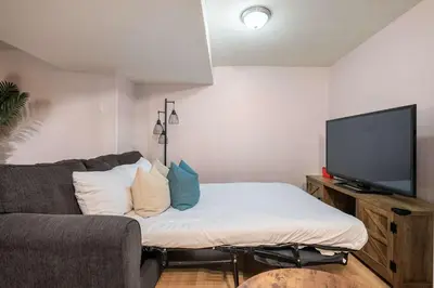 a living room with a couch and a flat screen tv at The Arizona 2BR Pet-Friendly Suite Calgary SE in Calgary