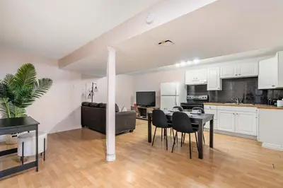 a kitchen and living room with a table and chairs at The Arizona 2BR Pet-Friendly Suite Calgary SE in Calgary