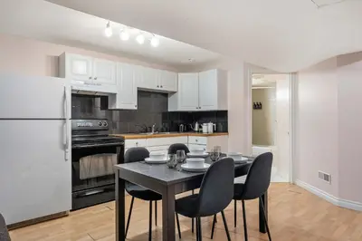 a kitchen with a table and chairs and a refrigerator at The Arizona 2BR Pet-Friendly Suite Calgary SE in Calgary