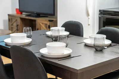 a table with plates and wine glasses on it at The Arizona 2BR Pet-Friendly Suite Calgary SE in Calgary