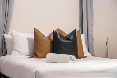 a bed with a bunch of pillows on it at The Arizona 2BR Pet-Friendly Suite Calgary SE in Calgary