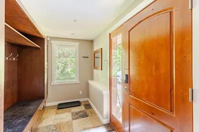a hallway with a large wooden door and a window at Crystal Ridge by Whistler Retreats in Whistler
