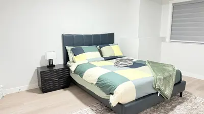 a bedroom with a large bed with a black headboard at Zillion’s Bliss - Basement Suite in Calgary