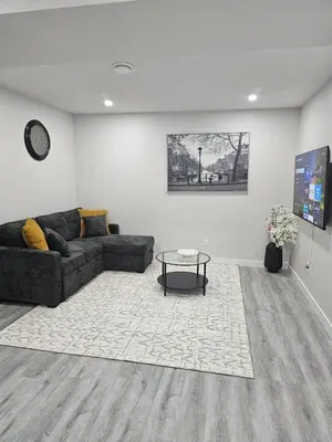 a living room with a couch and a table at Cozy on 516 in Airdrie