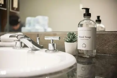 a bottle of liquid soap sitting on a bathroom sink at Le Chamois 307 by Outpost Whistler in Whistler
