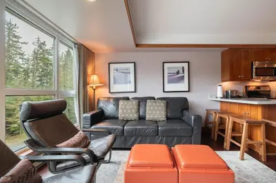 a living room with a couch and a table at Le Chamois 307 by Outpost Whistler in Whistler