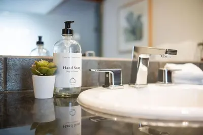 a bottle of hand soap sitting on a bathroom sink at Le Chamois 307 by Outpost Whistler in Whistler