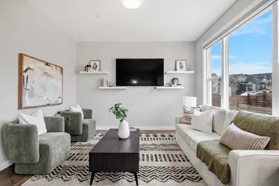 a living room with a couch and chairs and a tv at The Herron Rise Retreat in Calgary