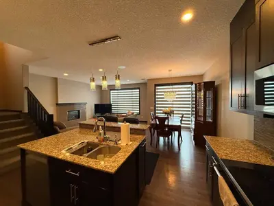 a kitchen and living room with a sink and a counter at Panorama Haven in Calgary