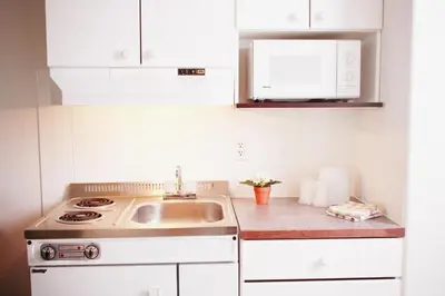 a kitchen with a sink and a stove at Country Club Inn in Lacombe