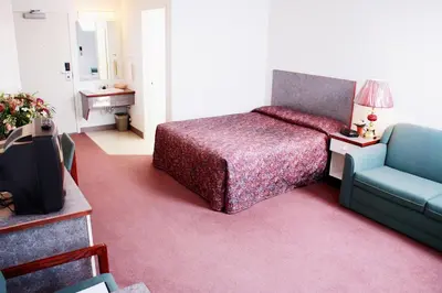 a bedroom with a bed and a couch and a television at Country Club Inn in Lacombe