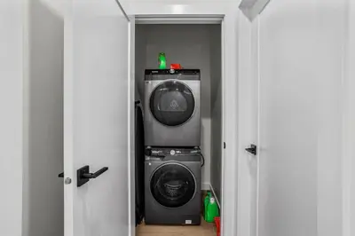 a washer and dryer in a room with two doors at 4BR Luxury Mountain Retreat Private HotTub Sleeps 17 in Canmore