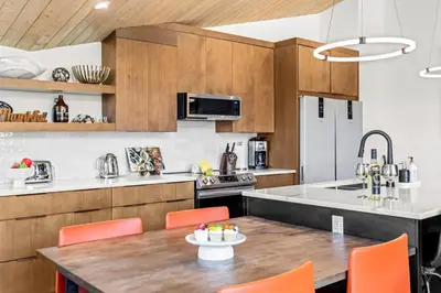 a kitchen with a table and chairs and a kitchen with a refrigerator at 4BR Luxury Mountain Retreat Private HotTub Sleeps 17 in Canmore