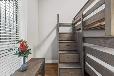 a bedroom with a bunk bed and a wooden table at Luxury 4BR with Hot Tub Mtn Views 10Min Walk to DT in Canmore