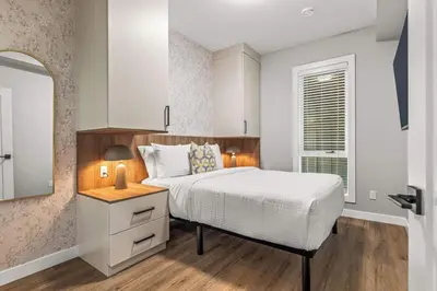 a bedroom with a white bed and a window at Luxury 4BR with Hot Tub Mtn Views 10Min Walk to DT in Canmore