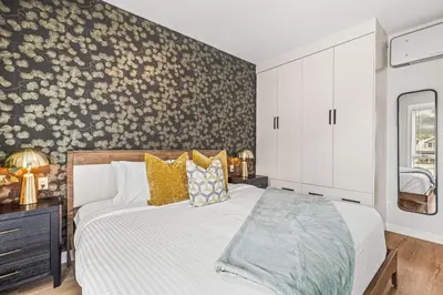 a bedroom with a bed with a floral accent wall at Luxury 4BR with Hot Tub Mtn Views 10Min Walk to DT in Canmore