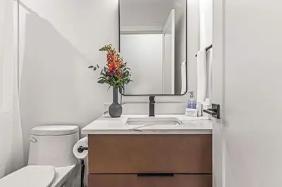 a bathroom with a sink and a vase with flowers in it at Luxury 4BR with Hot Tub Mtn Views 10Min Walk to DT in Canmore