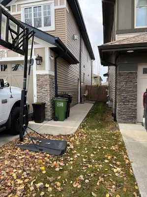 a house with a yard with leaves on the grass at Cozy 2BR Retreat | Edmonton SW | Smart TV + Wi-Fi in Edmonton