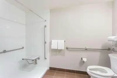 a white bathroom with a toilet and a sink at Microtel Inn and Suites by Wyndham Kitimat in Kitimat