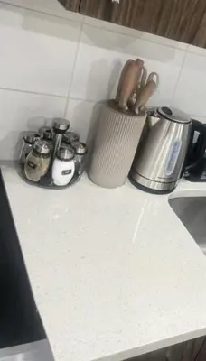 a counter top with a cup and utensils on it at Modern 1BR Suite Sleeps 3-4 in Near YYC Calgary Airport in Calgary