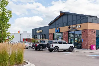 a dealership with a white truck parked in a parking lot at Modern 1BR Suite Sleeps 3-4 in Near YYC Calgary Airport in Calgary