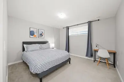 a bedroom with a bed and a desk and a window at Modern 1BR Suite Sleeps 3-4 in Near YYC Calgary Airport in Calgary