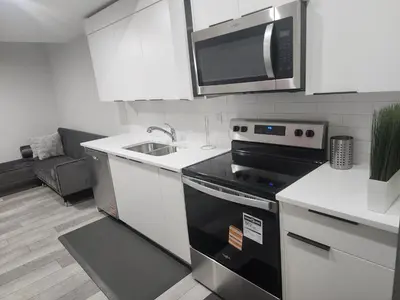 a kitchen with a stove and a microwave at Stylish furnished 2bedroom suite near YYC Airport in Calgary