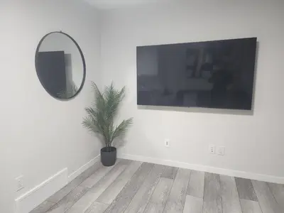 a white room with a mirror and a potted plant at Stylish furnished 2bedroom suite near YYC Airport in Calgary