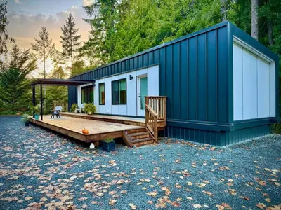a tiny house with a large porch and a deck at Island Coastal Retreat in Qualicum Beach