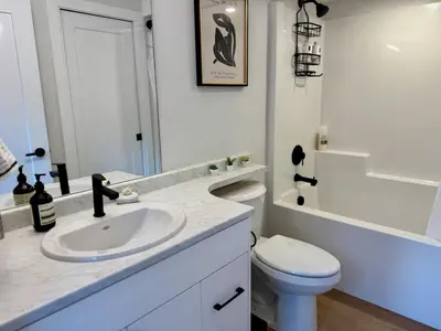 a white bathroom with a sink and a toilet at Island Coastal Retreat in Qualicum Beach