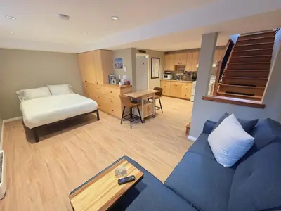 a living room with a blue couch and a bed at NEW Midtown Rossland Studio Apartment in Rossland