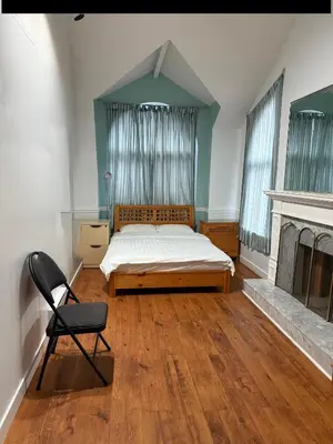 a bedroom with a bed and a chair and a fireplace at EXTRA Large Suite with Ensuite Bathroom, Microwave & Fridge in Richmond