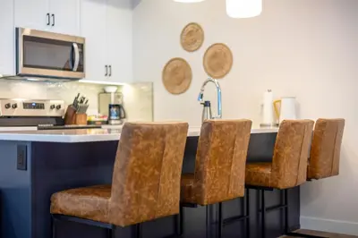 a kitchen with a counter with a bar stools at Four Bears Chalet by Fernie Central Reservations in Fernie
