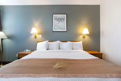 a large bed in a hotel room with two lamps at Lakeview Inns & Suites - Okotoks in Okotoks