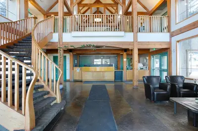 a large lobby with a staircase and chairs at Lakeview Inns & Suites - Okotoks in Okotoks